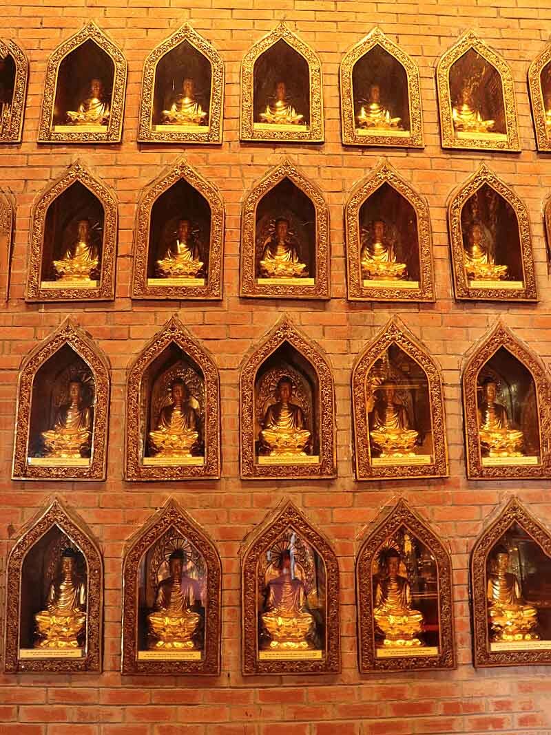 unzählige kleine Buddhas, von Leuten gespendet, zieren überall auf dem Pagodengelände die Wände